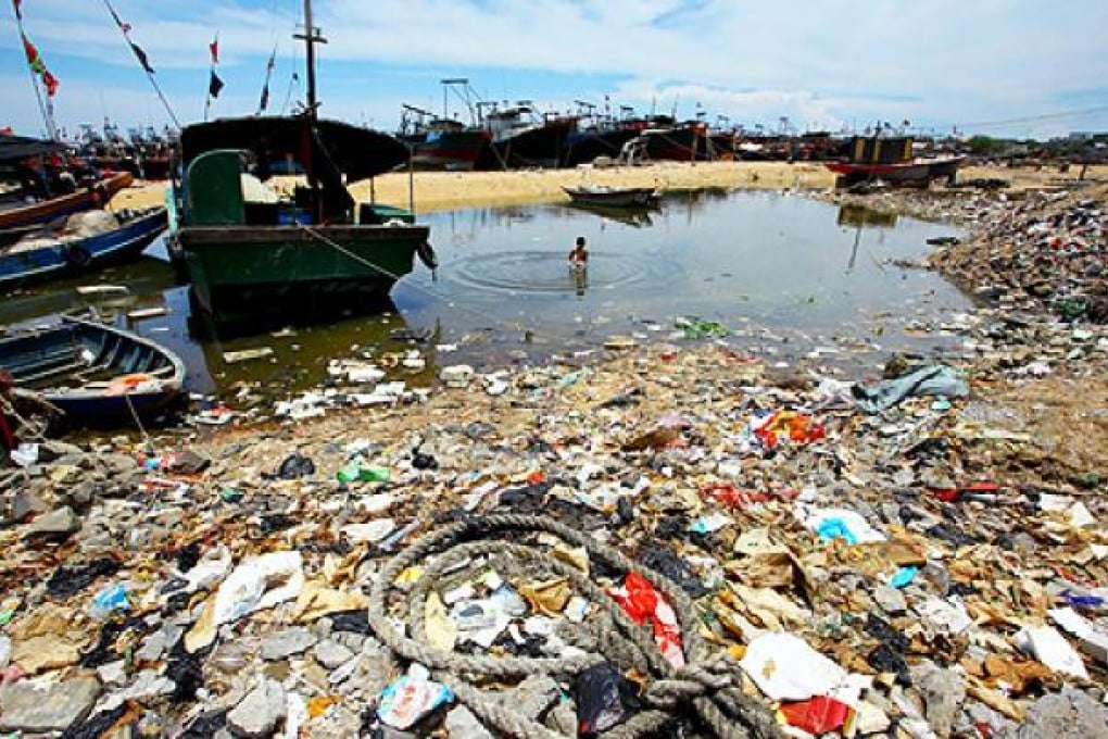 A Chinese boy swims in the sea by a rubbish-strewn beach along the sea coast in Anquan village, south China's Hainan province. Photo: AFP