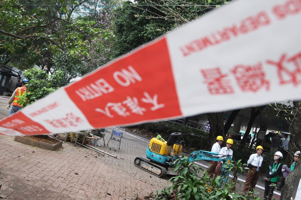 Workers setting up a cordon around the empty site at Pai Tau village. It has been used as a car park. Photo: Sam Tsang