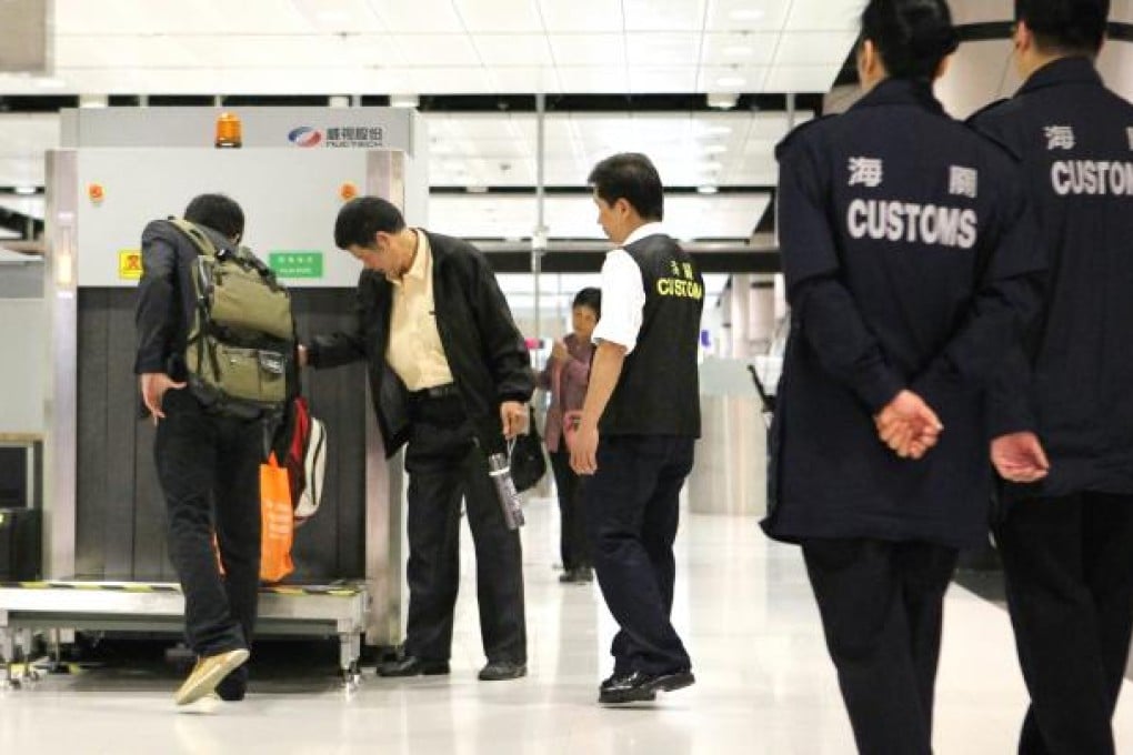 Customs officers inspect luggage at Lok Ma Chau. Photo: Edward Wong