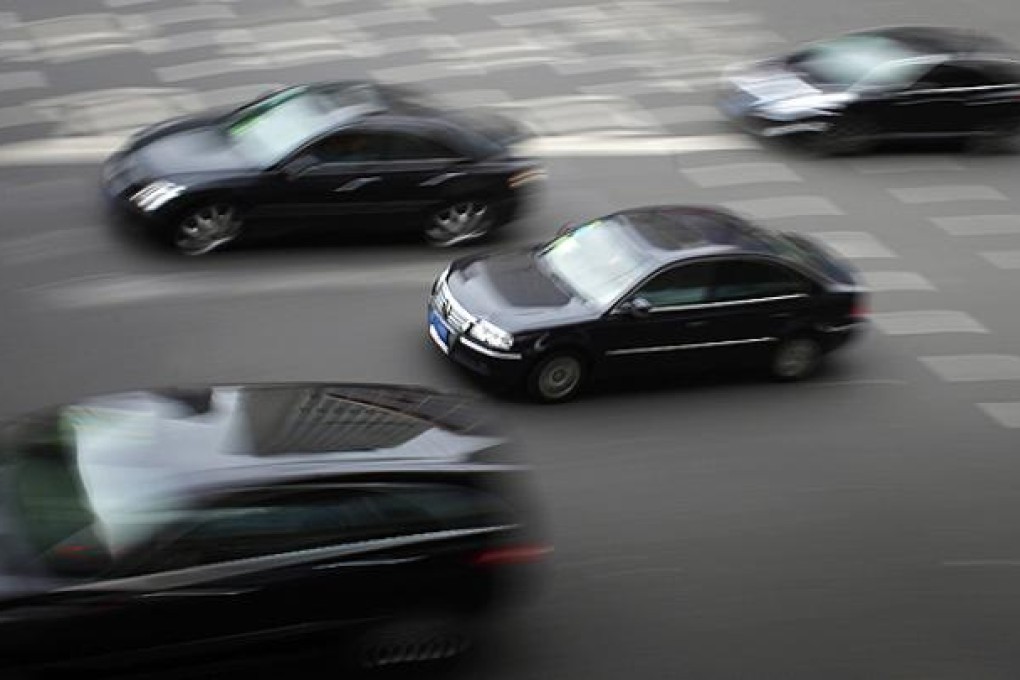 A Volkswagen Passat drives along a busy street in downtown Shanghai. Photo: Reuters