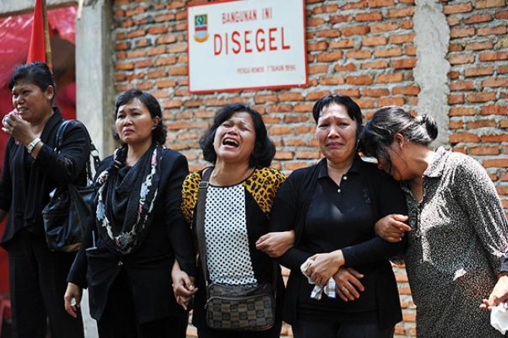 Indonesian congregation members of the Taman Sari Batak Christian Protestant Church stand in front of their church. Photo: AFP