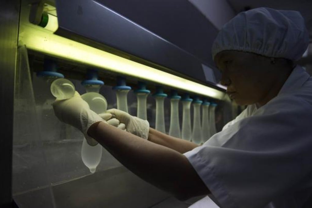 A Karex worker checks randomly selected condoms for leakage.