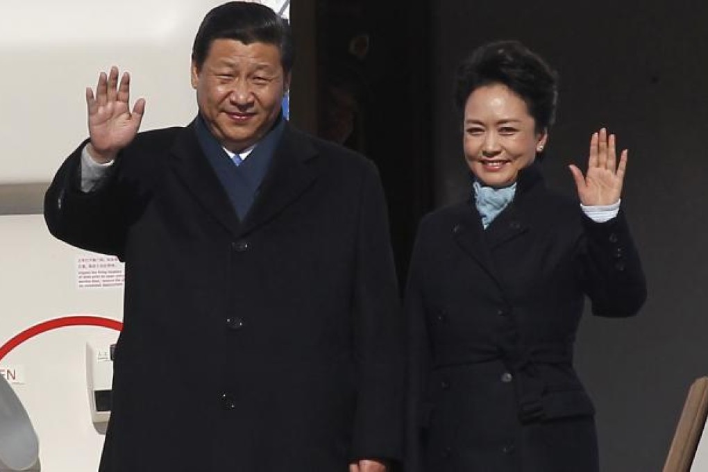Chinese President Xi and First Lady Peng wave as they arrive at Moscow's Vnukovo airport. Photo: Reuters