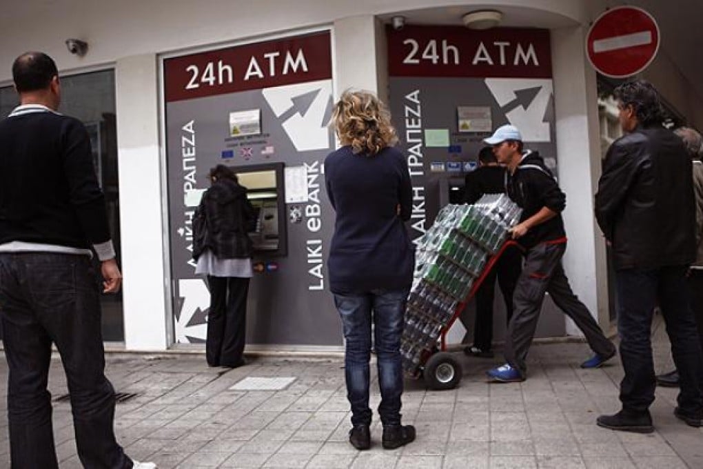 Cypriots withdraw cash from ATM machines in the capital Nicosia. Photo: AP