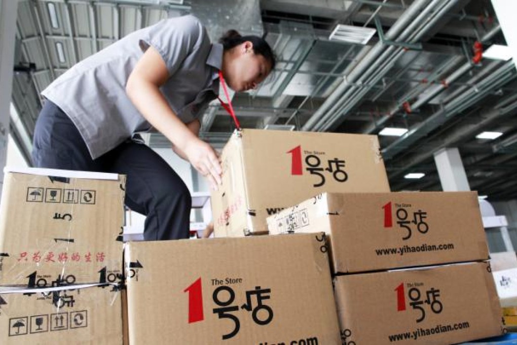 An employee packages items into boxes to fill orders at the Yihaodian (The Store) warehouse in Shanghai. Photo: Bloomberg