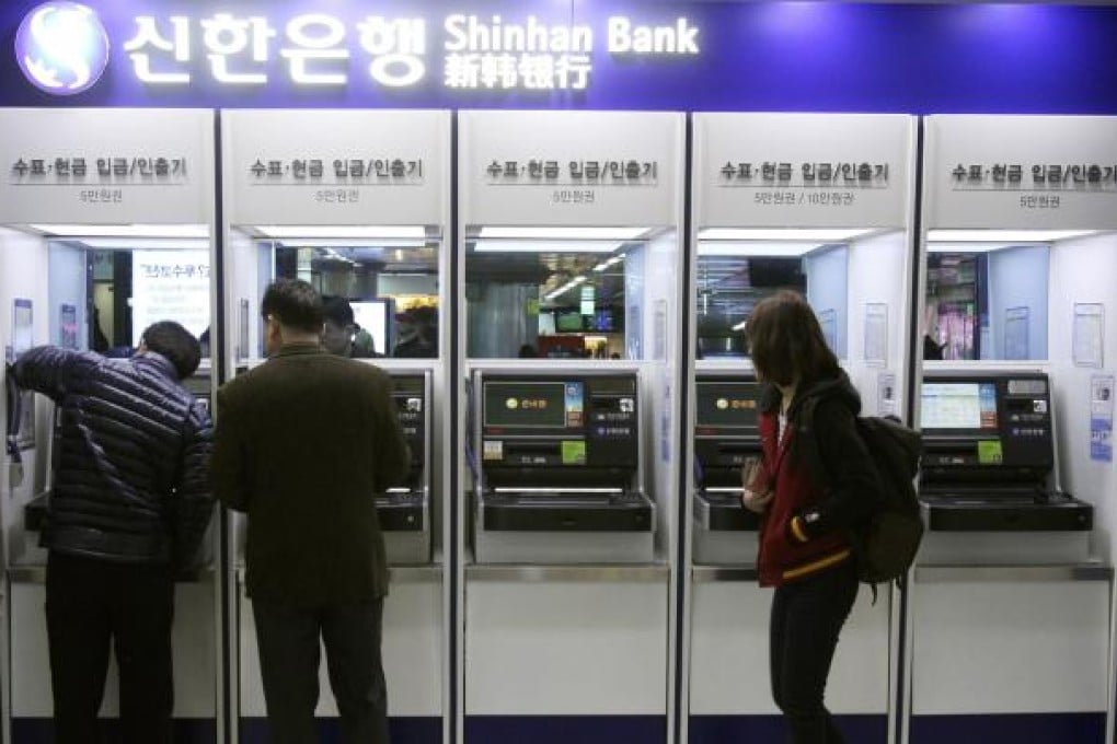 Depositors try to use automated teller machines of Shinhan Bank while the bank's computer networks are paralysed, at a subway station in Seoul. Photo: AP
