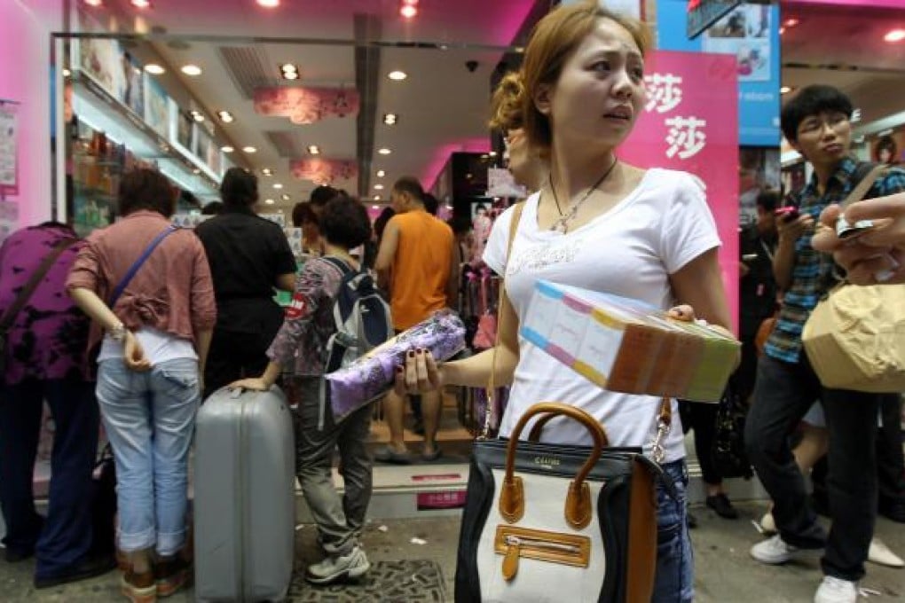Mainland tourists are seen at a cosmetics shop in Mong Kok. Local stores can often provide better deals for quality products than big-name malls. Photo: SCMP