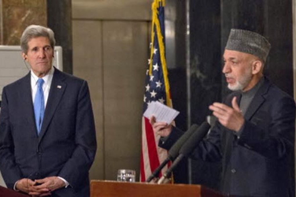 US Secretary of State John Kerry listens as Afghan President Hamid Karzai speaks during their joint news conference at the presidential palace in Kabul. Ph