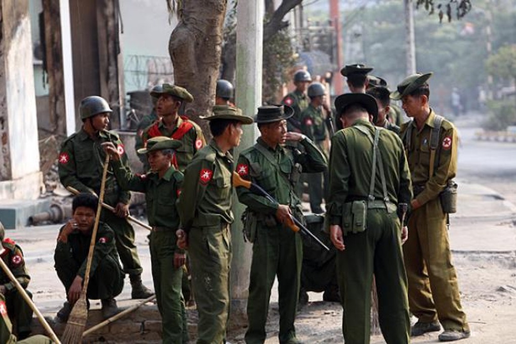 Myanmar soldiers take a break as they remove debris from destroyed buildings following the ethnic unrest between Buddhists and Muslims in Meikhtila. Photo: AP