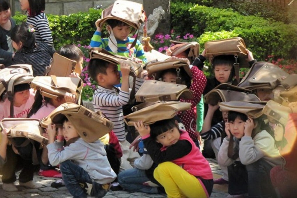 Schoolchildren brace themselves after a magnitude 6.1 quake struck Nantou in Taiwan yesterday. It was felt as far away as Shanghai and Hong Kong. Photo: SCMP