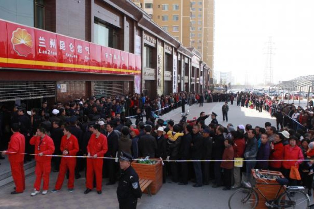 People queue up outside a gas station to buy natural gas in Lanzhou, northwest China's Gansu province. Photo: AFP