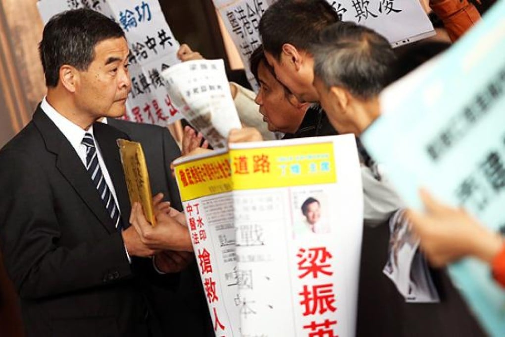 Chief Executive Leung Chun-ying receives a package from protesters at government headquarters in Admiralty yesterday. Photo: Sam Tsang