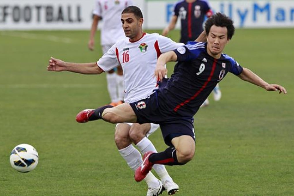 Japan's Okazaki fights for the ball against Jordan's Othman at King Abdullah stadium in Amman. Photo: Reuters