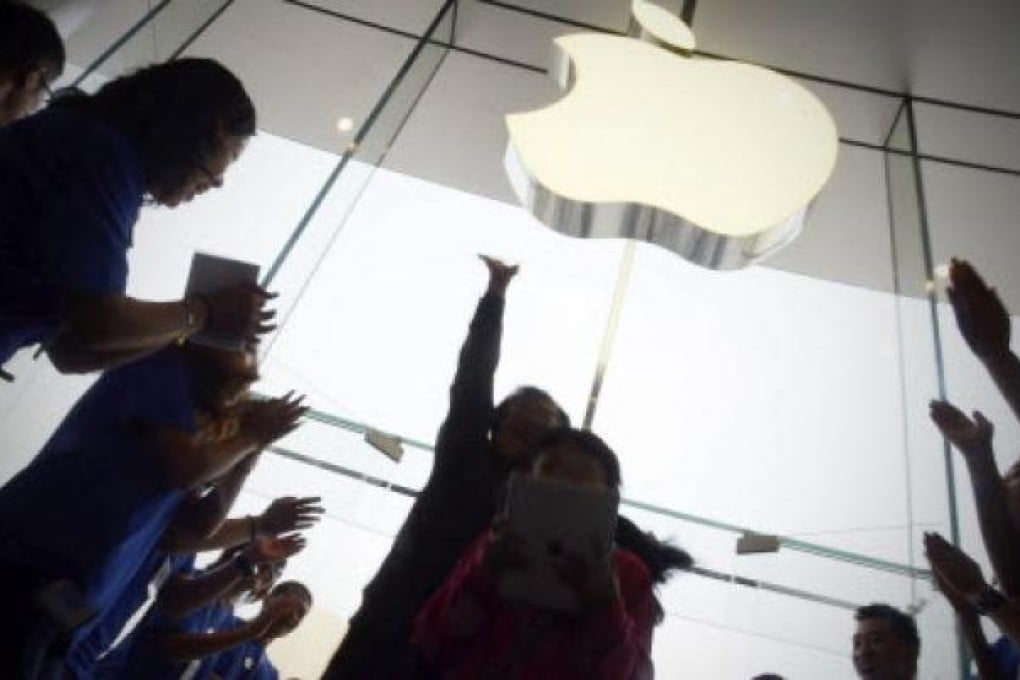 Apple staff welcome customers in an Apple store at WangFujin business district in Beijing. Photo: AFP