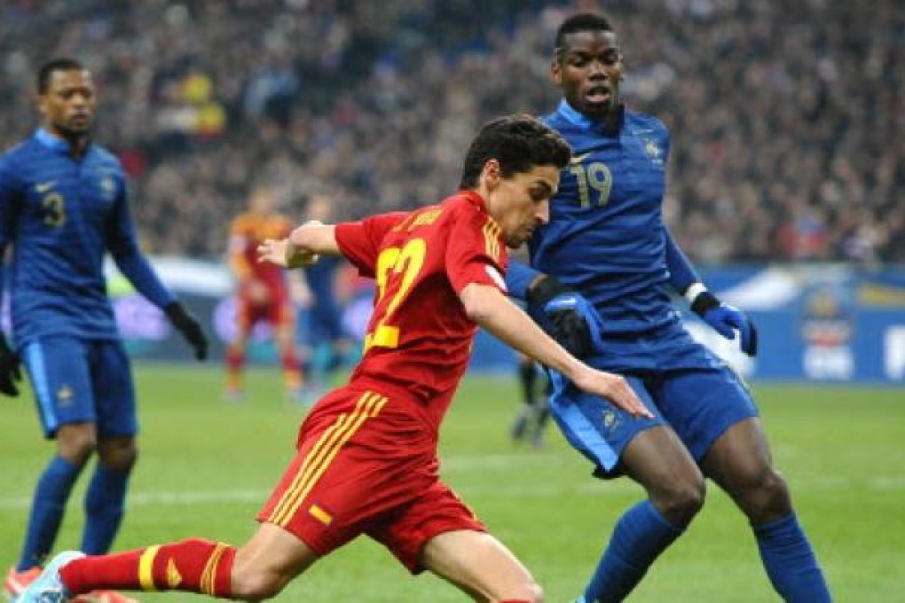 Spain's midfielder Jesus Navas (centre) beside France's midfielder Paul Pogba (right) during the World Cup 2014 qualifying football match France vs Spain on Tuesday in Saint-Denis, outside Paris. Photo: AFP