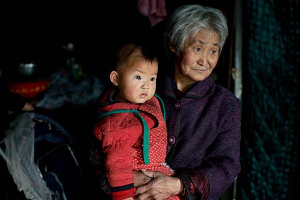 A woman holds one of her grandchildren in their home in Chengde, Hebei province, a town where inhabitants are not bound by the one-child birth-control policy enforced in other parts of China. Photo: AFP