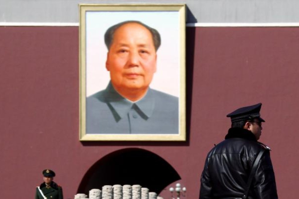 Policeman and paramilitary policeman stand guard in front of portrait of Mao in Tiananmen Square in Beijing. Photo: Reuters
