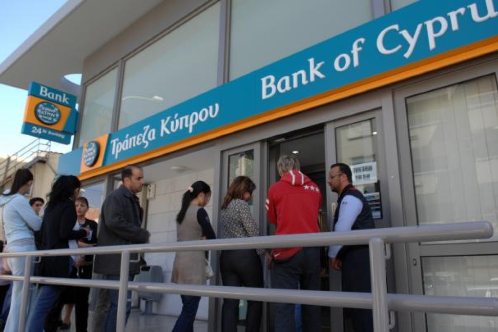 People wait outside a branch of Bank of Cyprus before the reopening of the bank in Nicosia, capital of Cyprus. Photo: Xinhua