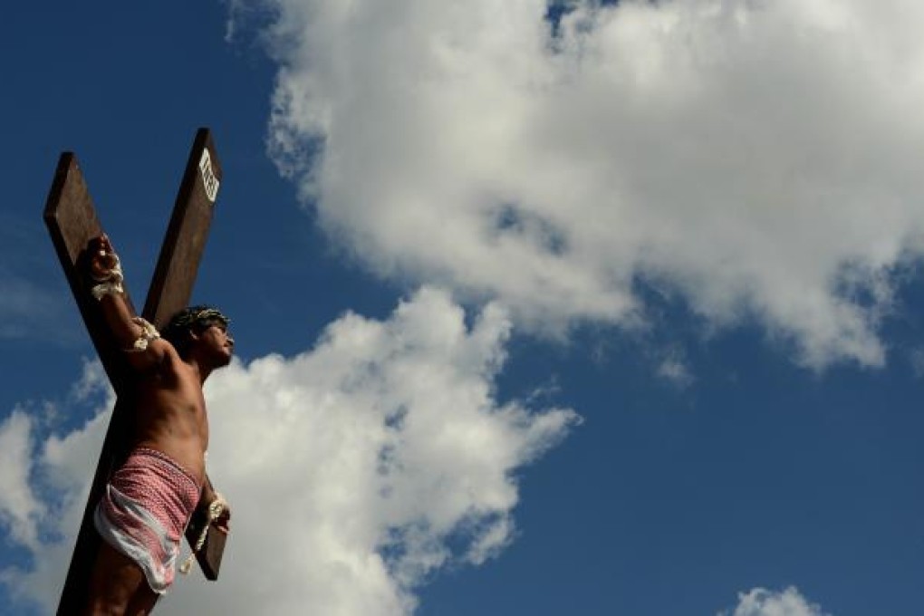 A penintent is nailed to a cross during the reenactment of crucifixion on Good Friday in the village of San Juan, San Fernando City, north of Manila. Photo: AFP