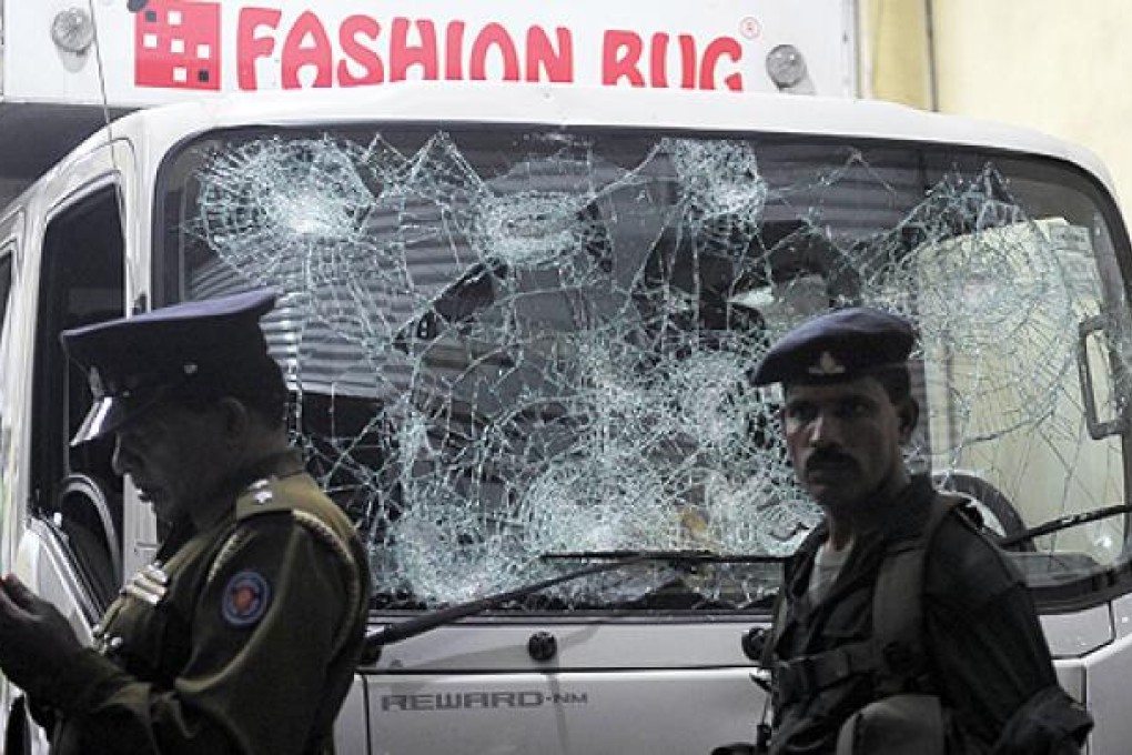 A policeman and a soldier stand guard outside the Muslim-owned Fashion Bug store at Pepiliyana, near Colombo, on Thursday. Photo: AFP