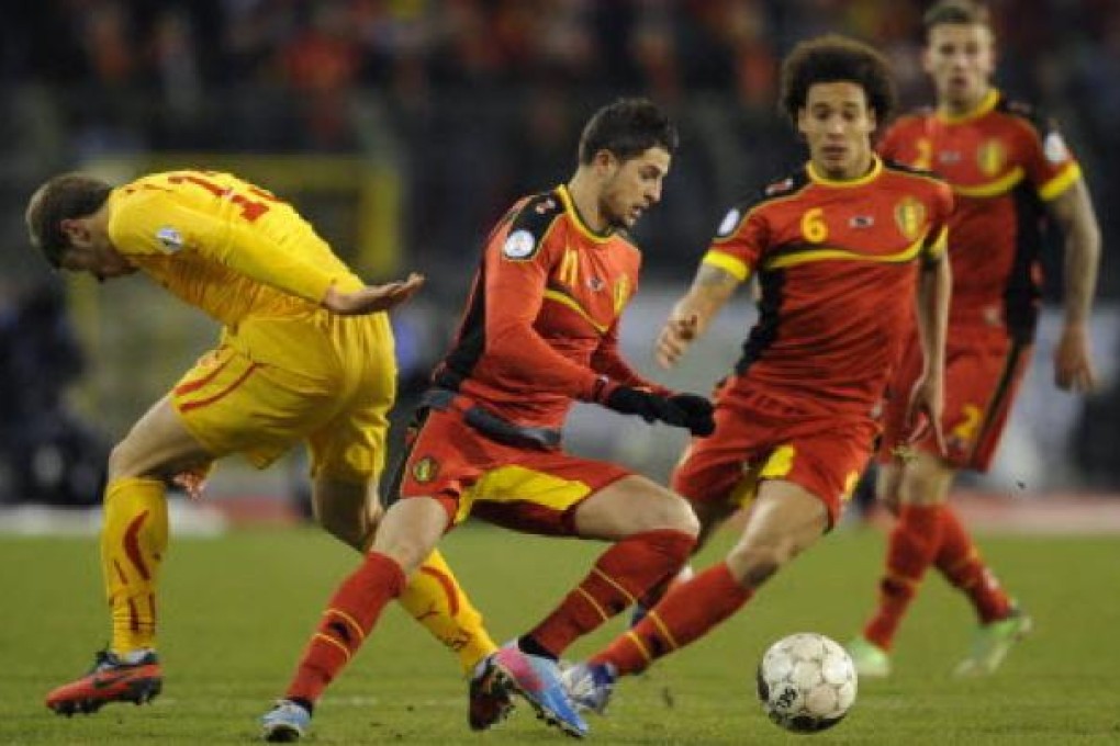 Macedonia's defender Stefan Ristovski (L) and Belgium's forward Kevin Mirallas (C) fight for the ball during the 2014 World Cup qualifying football match between Belgium and Macedonia. Photo: AFP