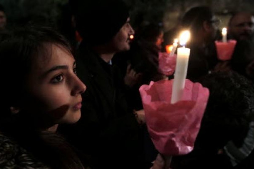 A faithful holds a candle as Pope Francis leads the Via Crucis (Way of the Cross) procession during Good Friday celebrations. Photo:Reuters