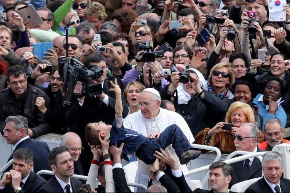Pope Francis lays his hands on a disabled child during yesterday's Easter Sunday mass attended by tens of thousands of worshippers at the Vatican's Saint Peter's Square. Photo: EPA