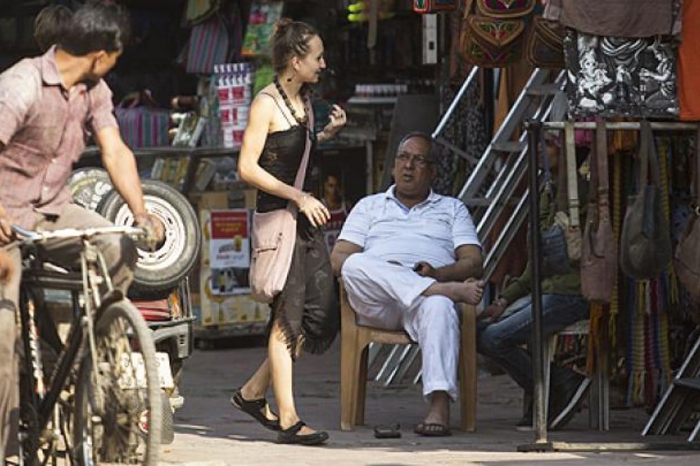 Two Indian men watch a foreign tourist at a market in New Delhi. Campaigners have welcomed a toughening of laws in India for sex crimes but have said they are not enough to tackle a crisis underpinned by cultural attitudes. Photo: AFP