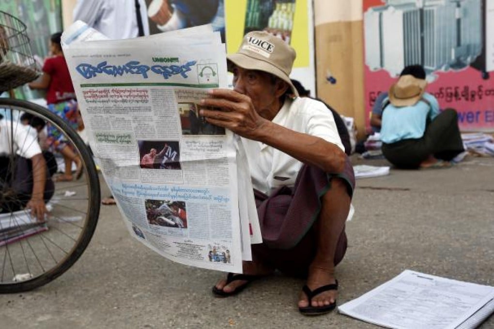 A man reads a newspaper on the roadside in Yangon, Myanmar, on Monday. Photo: Xinhua