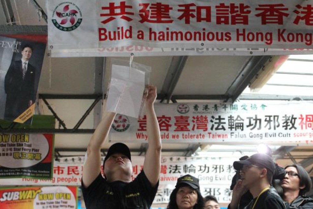 A Food and Environmental Hygiene Department official puts up a letter demanding the banners' removal. Photo: Felix Wong