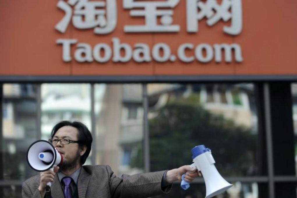 A man holds loudspeakers at the entrance to the Taobao office during a protest in Hangzhou, Dec.16 2011. (Photo: Reuters)