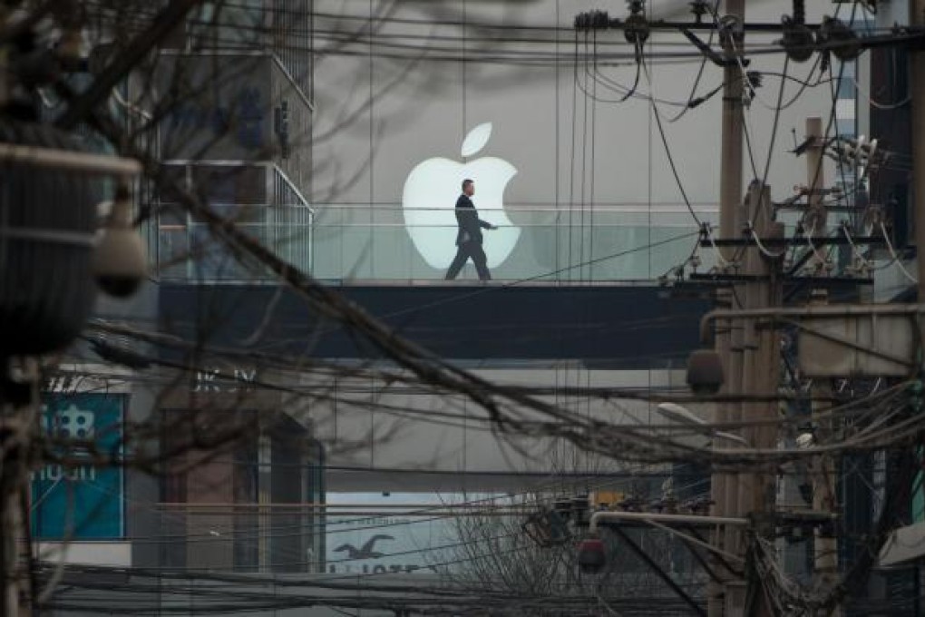 A man strolls on a walkway past an Apple logo on a shopping mall in Beijing. The company has apologised to mainland customers. Photo: AFP