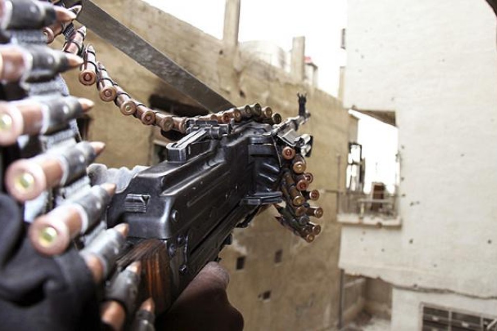A Free Syrian Army fighter guards the front line in the Sidi Meqdad suburb of Damascus. Photo: Reuters