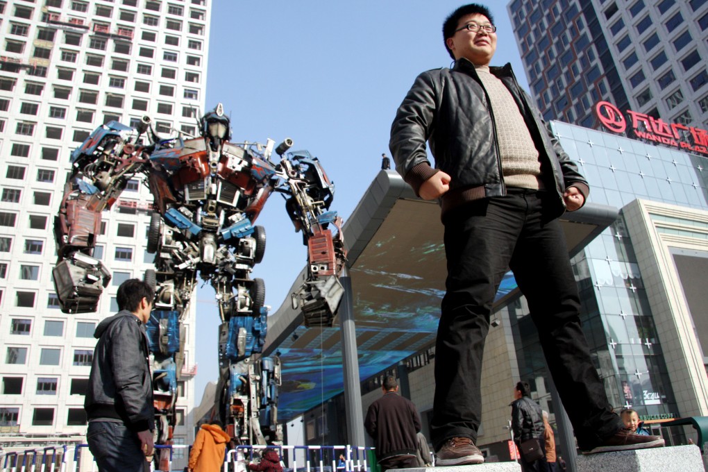 Pedestrians walk past an 'Optimus Prime' replica built out of recycled auto parts at Wanda Square in Jinan, capital of eastern China's Shandong Province. Photo: Xinhua
