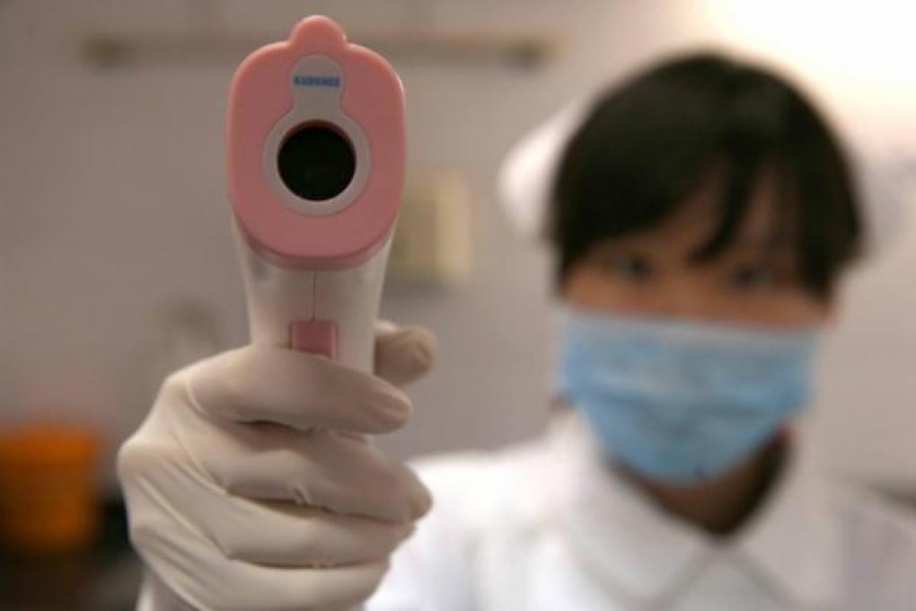 A nurse uses a body temperature detector in a hospital in Shanghai. Photo: EPA