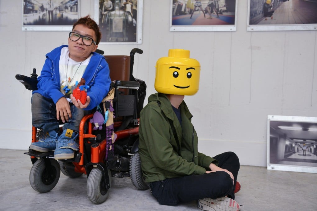 Photographer Kevin Cheng and the Lego man at his exhibition at the Jockey Club Creative Arts Centre. No one knows what's behind the mask, says Cheng. Photo: Thomas Yau