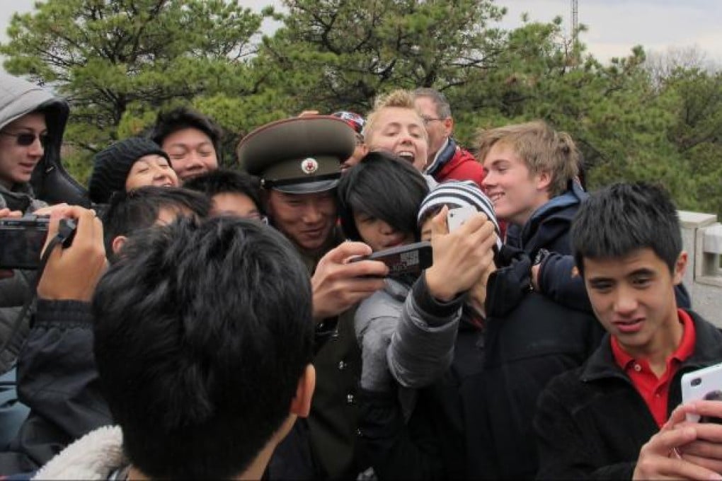 A smiling People's Army guard poses for photos with delighted students from the Chinese International School in Hong Kong in the demilitarised zone. Photo: Sean Guo