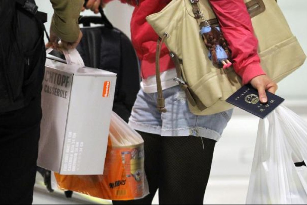 Custom officers inspect the luggages of people at Lok Ma Chau. The recent absurd situation over baby milk powder is the result of barriers to free trade. Photo: Edward Wong