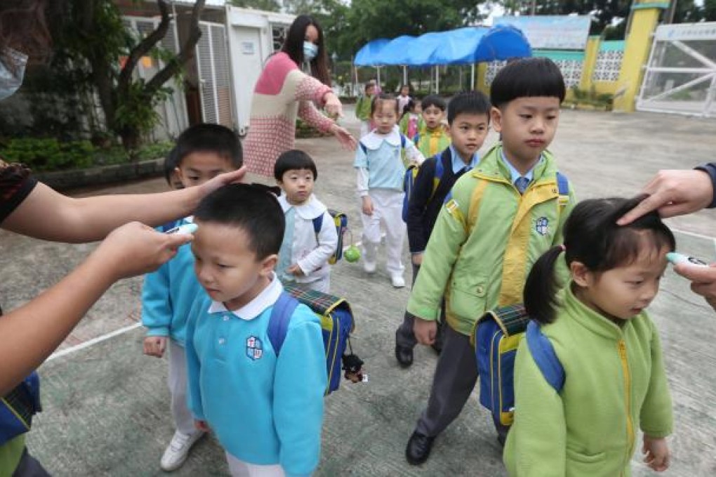 Pupils at Sheung Shui Pui Yau Kindergarten undergo temperature checks before entering classes. Photo: Sam Tsang