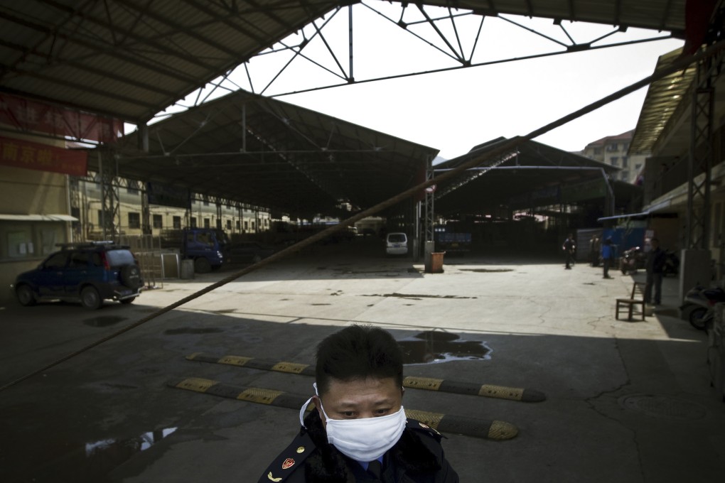 A security guard wearing a face mask stands guard at a poultry market which has been closed by local government officials in Nanjing, eastern China's Jiangsu province. Photo: AP