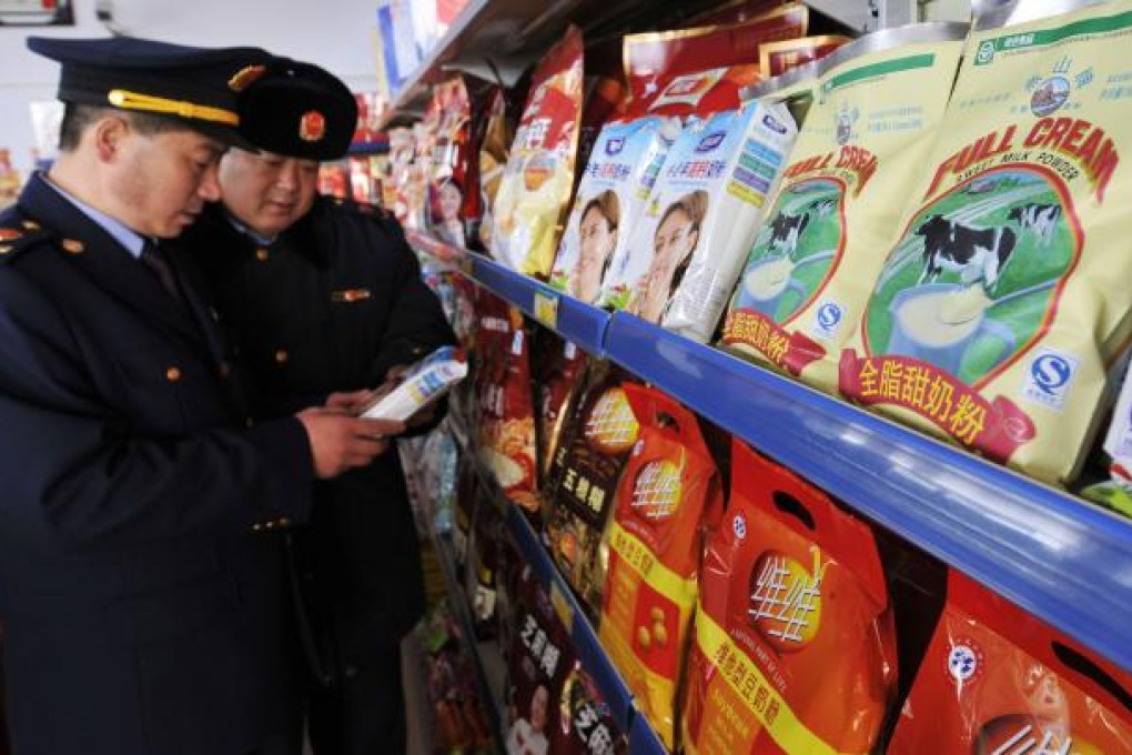 Business administration officers check dairy products in a supermarket in Rizhao, in east China's Shandong province. Photo: AP