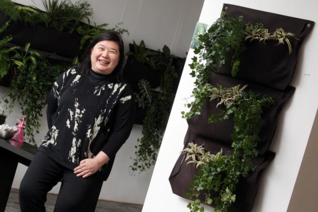 Margaret Chen, founder of SquAir Spaces, poses with the 'living walls' of plants at her office in Wong Chuk Hang. Photo: May Tse