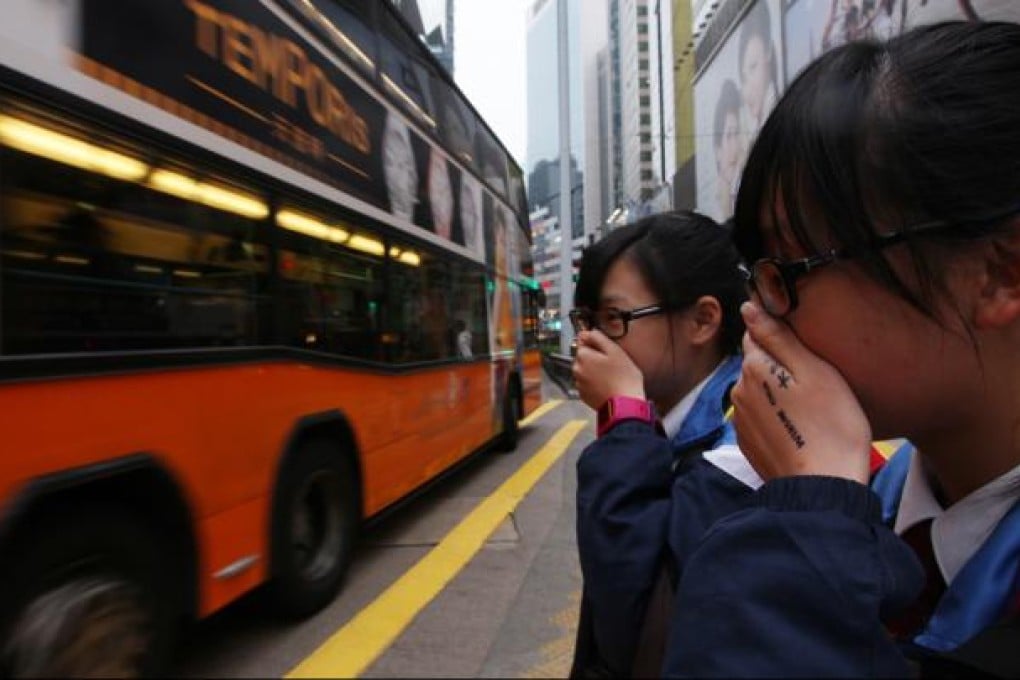Students cover up to avoid traffic fumes. Photo: Nora Tam