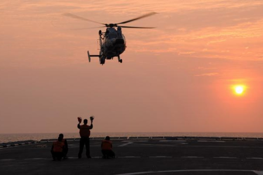 A Z-9 helicopter prepares to land on the warship Jinggangshan in waters near south China's Hainan Province. Photo: Xinhua