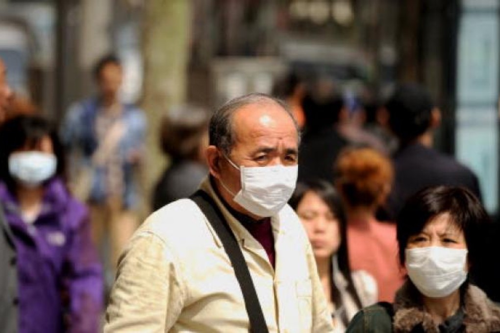 People wear masks as a precaution against bird flu on a street in Shanghai. Photo: AFP