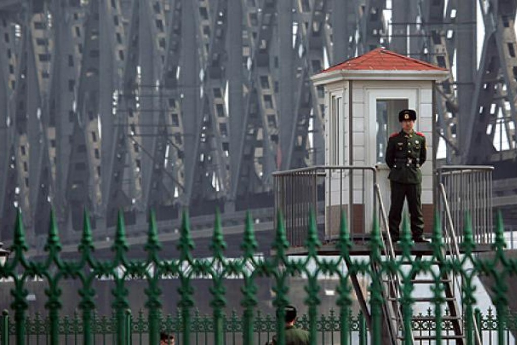 A Chinese border guard in Dandong guards a post by a bridge the crosses the Yalu river to North Korea. Photo: AFP