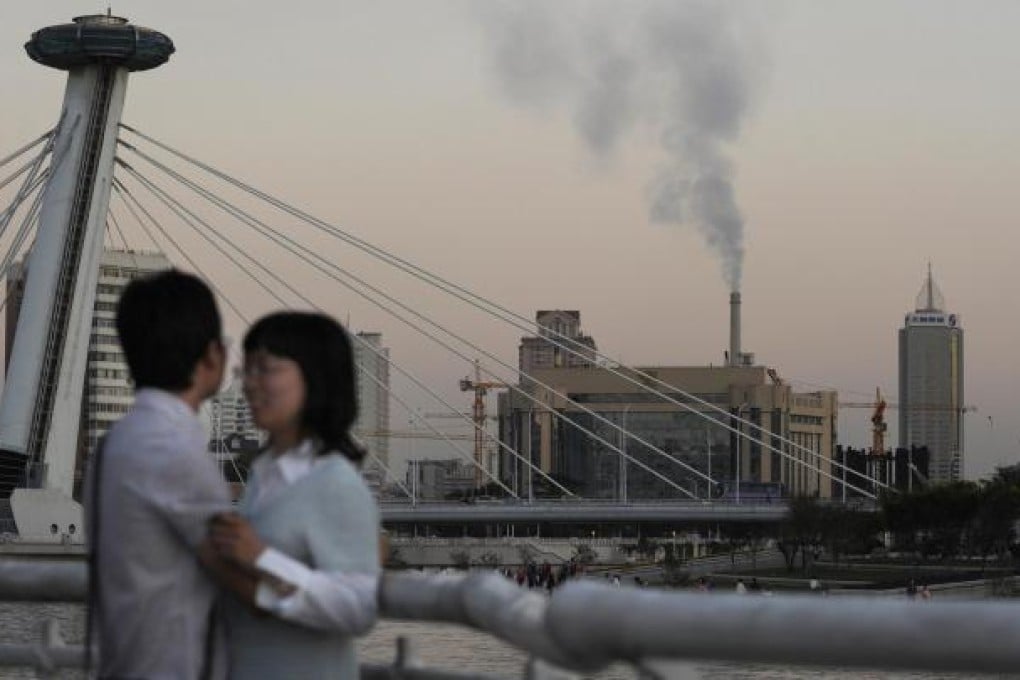 A couple embrace in smoggy Tianjin, which has slipped nine places in an annual air quality report. Photo: AFP