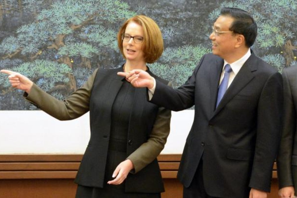Australian PM Julia Gillard (left), pictured here with Chinese Premier Li Keqiang, encouraged telecoms giant Huawei to expand its commercial business in Australia during a trip to China this week. Photo: AFP