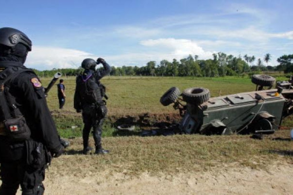 Thai security forces inspect the site of a roadside bomb attack on an armoured vehicle by suspected separatist militants which killed two soldiers and injured six in Thailand's restive southern province of Pattani. Photo: AFP