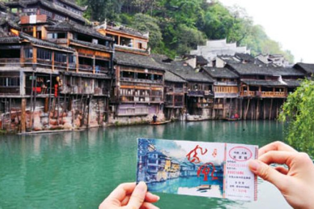 A visitor is holding an entry ticket in Fenghuang old town. Photo: Xinhua